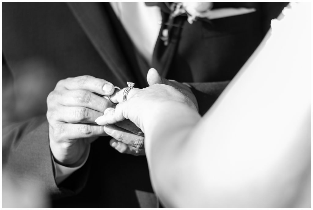 groom putting ring on bride's hand