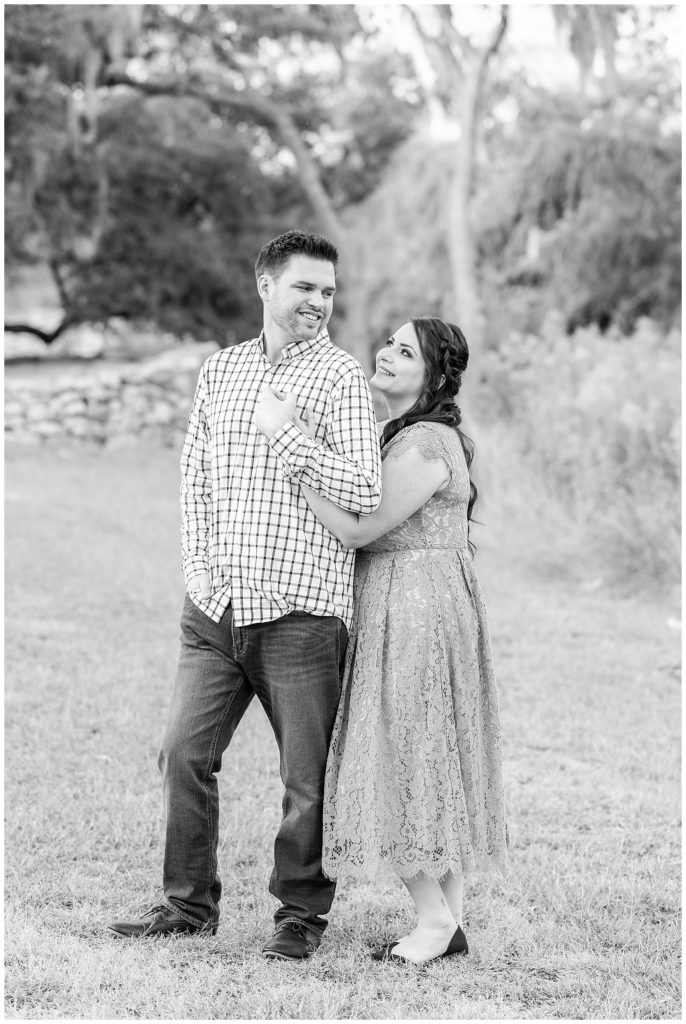 man and woman smiling for engagement photos