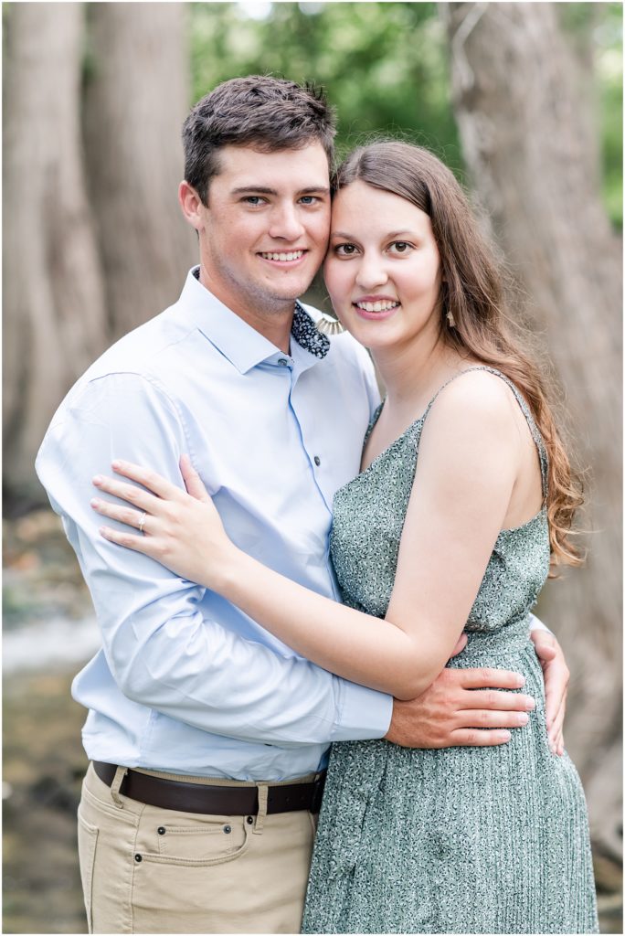 man and woman smiling for engagement photo at cibolo nature center