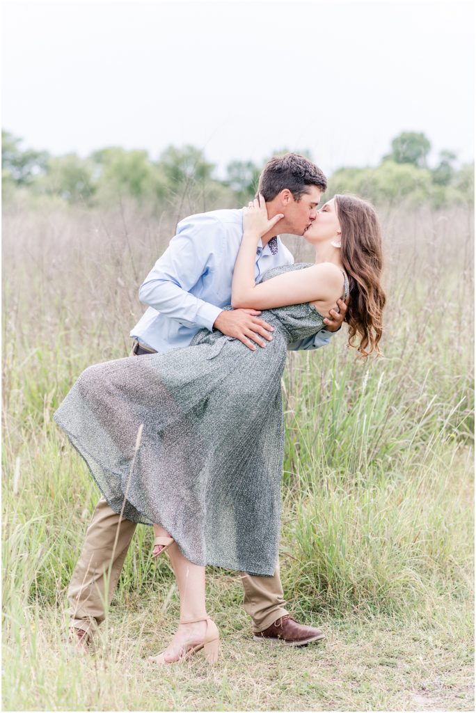 man dipping woman while he kisses her in field at cibolo nature center