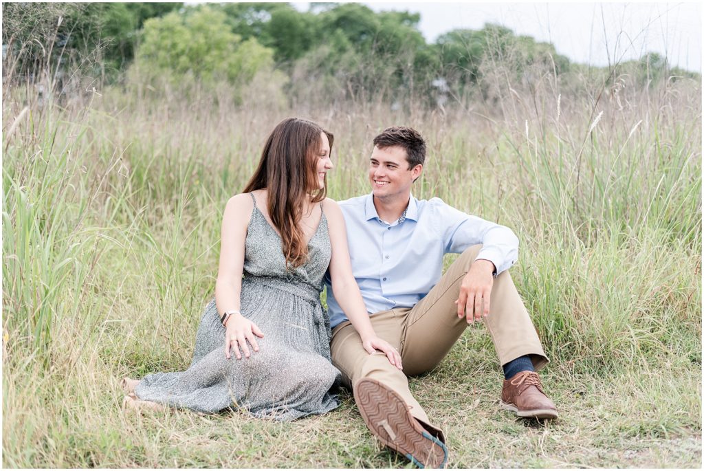 man and woman sitting in a field together at cibolo nature center
